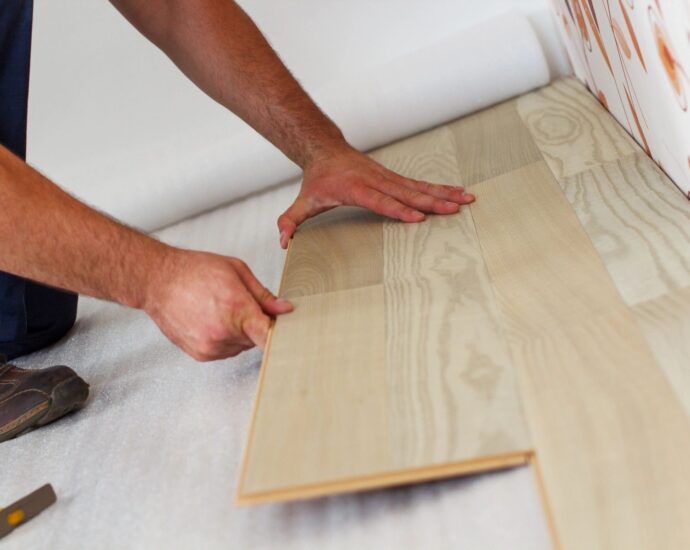 hands installing wood flooring
