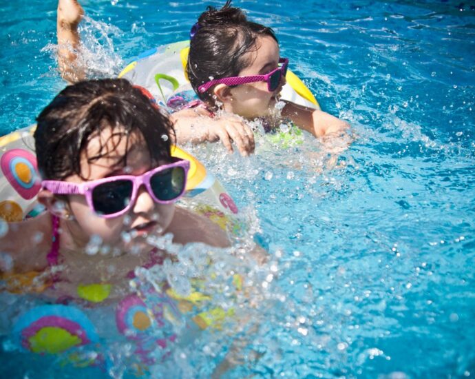 Little girls with sunglasses on in swimming pool