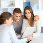 Insurance agent showing a young couple a document